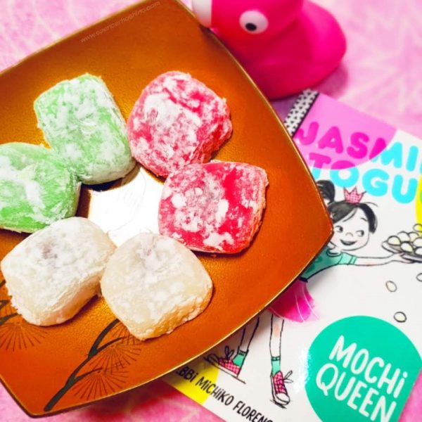 Photo of a plate of mochi, flamingo toy, and the book Jasmine Toguchi Mochi Queen by Debbi Michiko Florence